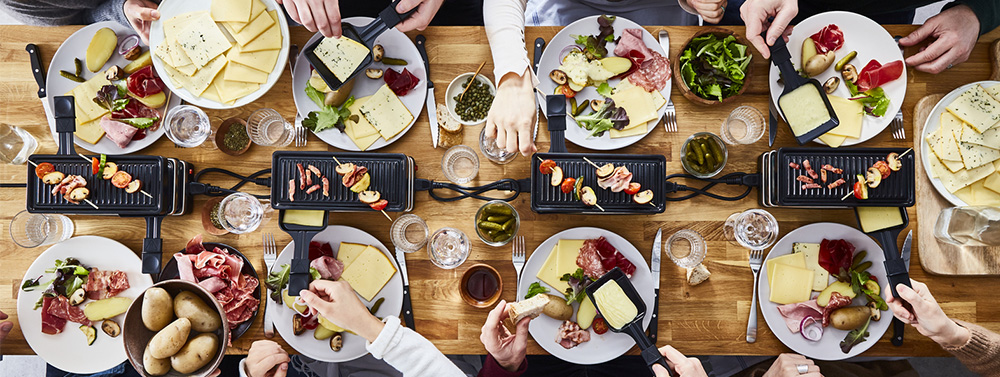 table de repas avec une raclette au centre